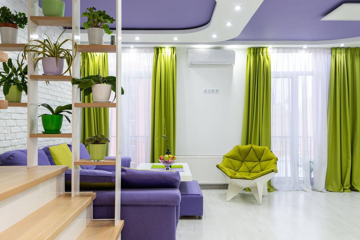 Lime green curtains over white sheers in a white living room with a purple sofa and a green armchair